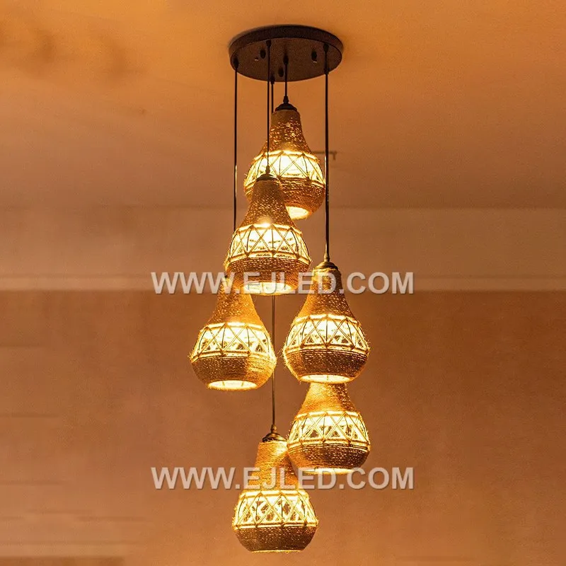 Woven from natural rattan, the RP0042 pendant light features three bell-shaped shades that direct light downwards while diffusing it through their open weave. It is designed for focused illumination over surfaces. - view 5