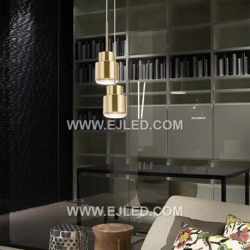 The MK0112 stands out with its tall, narrow cylindrical shade crafted from brass, featuring a distinct brushed brass finish. This clean-lined design offers a focused downlight, differentiating it from wider dome or cone pendants. - view 4