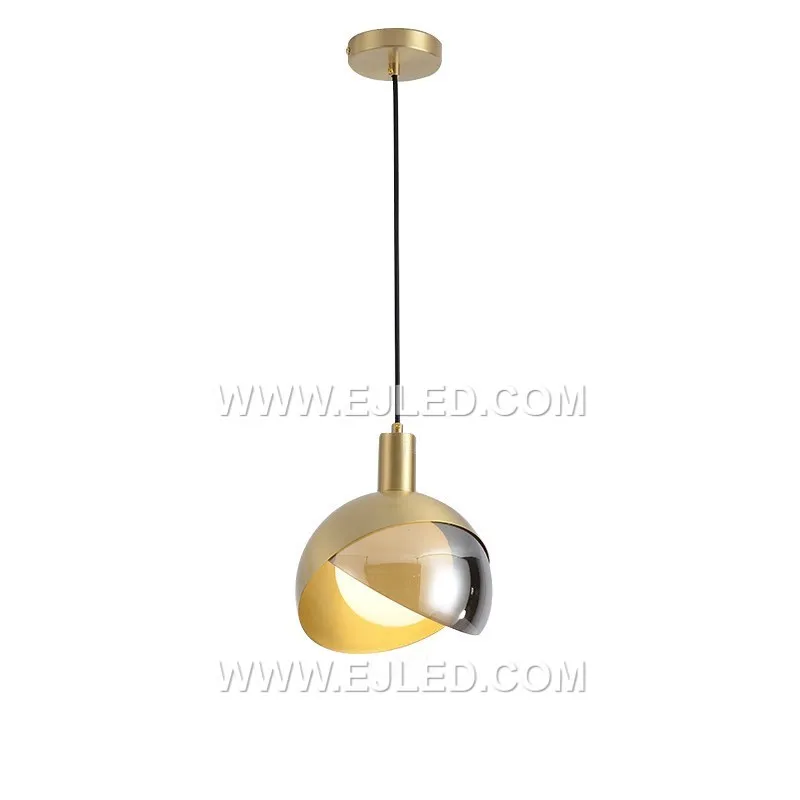 Esta lámpara colgante MK0114 combina una pantalla de vidrio transparente estriado verticalmente con detalles de latón, incluyendo una jaula decorativa interna para la bombilla. La suspensión de varilla rígida crea una silueta refinada, adecuada para iluminación enfocada en diversos interiores.