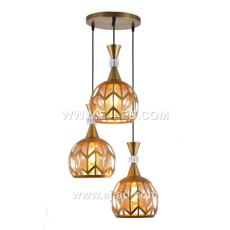 Esta distintiva lámpara colgante de tres luces se diferencia por sus cilindros individuales de latón con acabado dorado, cada uno con un patrón preciso cortado con láser alrededor de su circunferencia. Las diferentes alturas de suspensión crean un grupo en capas, proyectando luz con patrones hacia abajo.