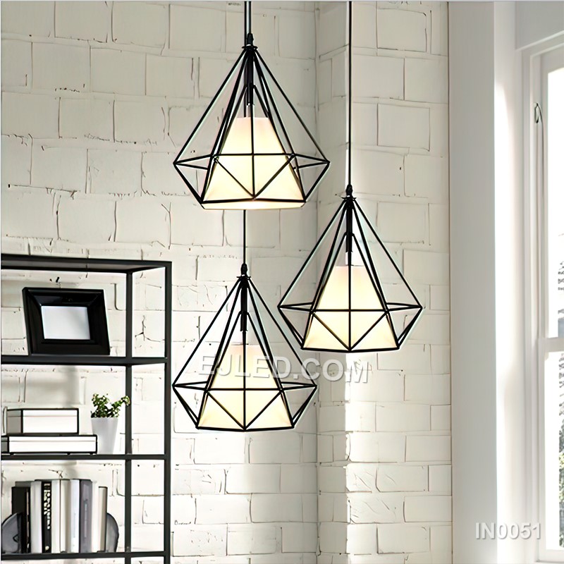 This IN0051 cluster pendant features three black iron diamond-shaped cages, each enclosing a spherical clear glass shade. Suspended at varying heights, it creates a visual centrepiece for rooms with higher ceilings. - view 2