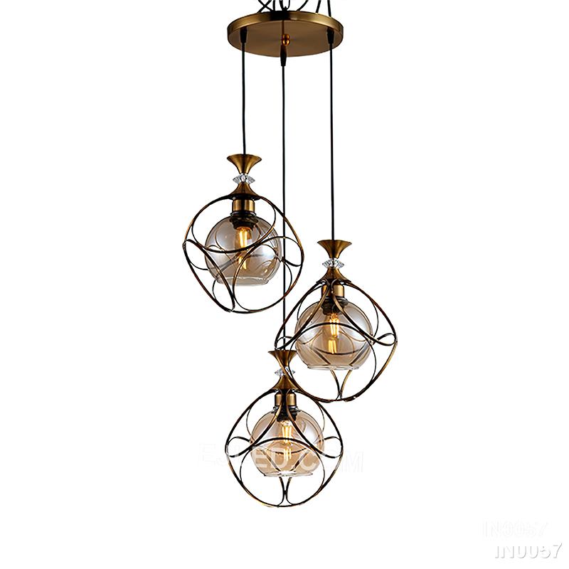 Round silhouettes define this three-light cluster pendant, where each brass-toned cage frames a clear glass globe, directing focused light downwards for general or task illumination. - view 4