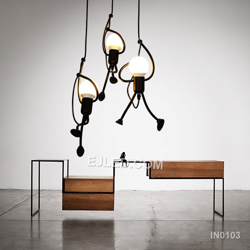 Suitable for adding character to stairwells, children's rooms, or creative hospitality settings, this fixture features three small, round black iron pendants. Playful human-like figures are integrated along each suspension cable, adding unique visual interest. - view 3