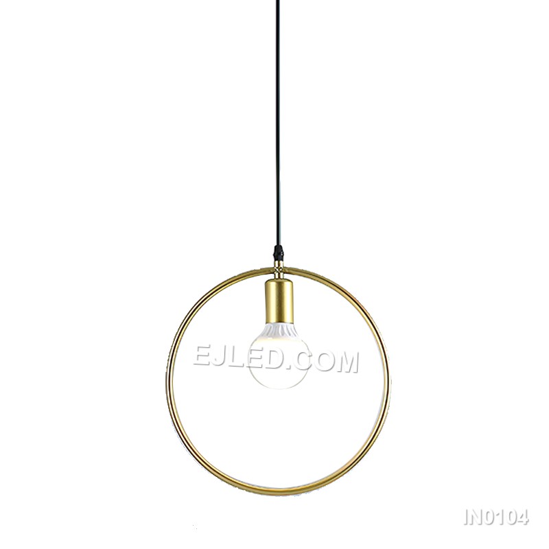 Three cylindrical brass cages form the IN0104 pendant light, each crafted from slender rods. These open frames, suspended from a linear bar, provide an exposed lamp design that diffuses light through the metallic structure.