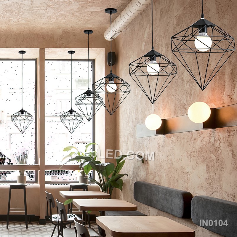 Three cylindrical brass cages form the IN0104 pendant light, each crafted from slender rods. These open frames, suspended from a linear bar, provide an exposed lamp design that diffuses light through the metallic structure. - view 4
