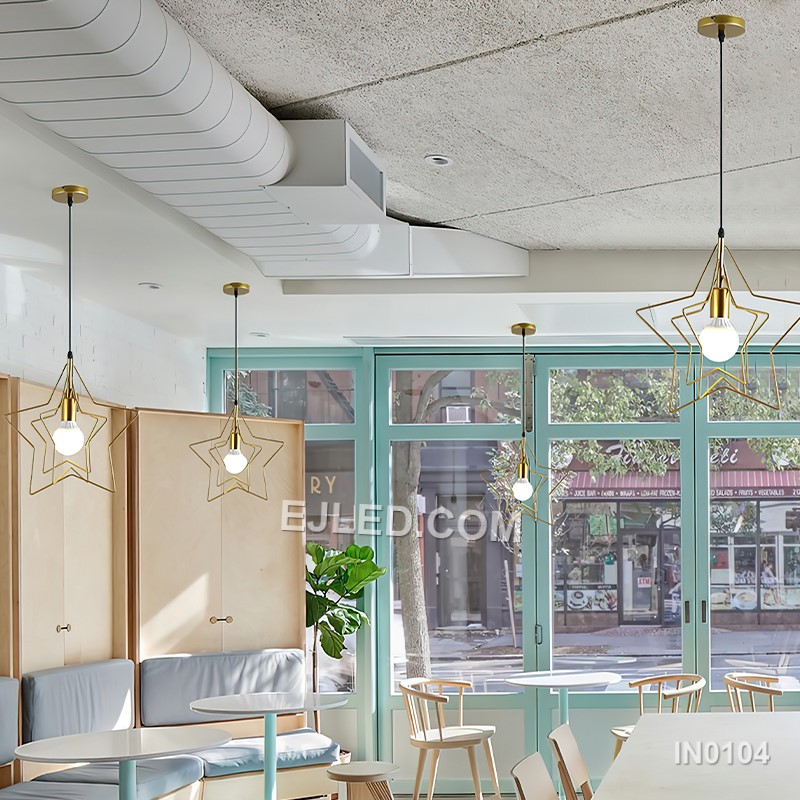 Three cylindrical brass cages form the IN0104 pendant light, each crafted from slender rods. These open frames, suspended from a linear bar, provide an exposed lamp design that diffuses light through the metallic structure. - view 5