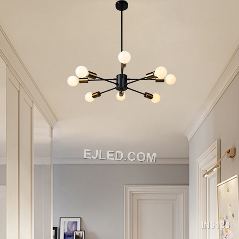 The IN0130 pendant light presents a large, 12-lamp sputnik design, ideal for substantial spaces. Its black steel body and radiating arms, each accented with a gold-toned collar, provide extensive, multi-directional illumination. This fixture hangs by a single cable from a matching black ceiling rose. - view 2