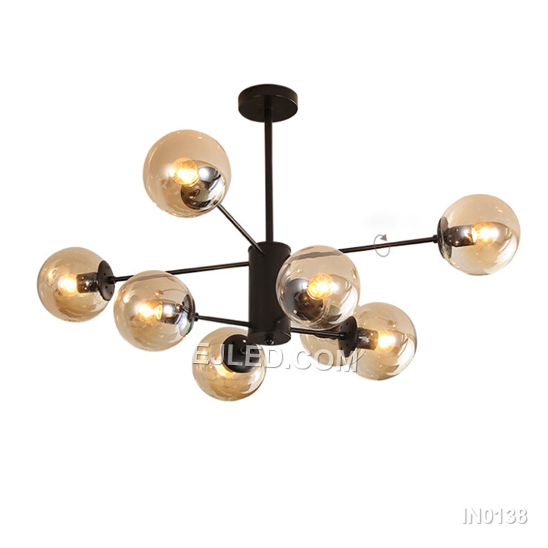 Distinct from simpler pendants, model IN0138 is an 8-light black steel chandelier, featuring a central hub with eight arms, each holding a clear spherical glass shade, offering widespread illumination.