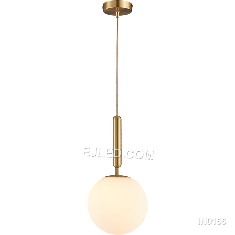 This single pendant light features a clear round glass shade encased by a polished brass frame. It suspends from a fabric-covered cord, casting a focused downlight and adding visual interest to dining areas, bedside tables, or compact reception spaces.