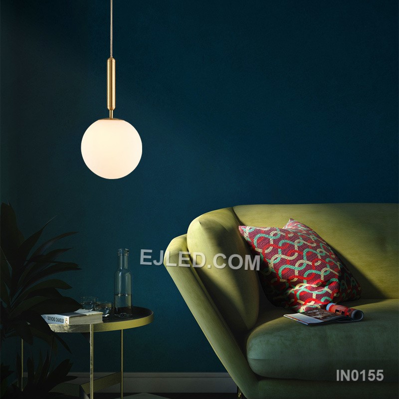This single pendant light features a clear round glass shade encased by a polished brass frame. It suspends from a fabric-covered cord, casting a focused downlight and adding visual interest to dining areas, bedside tables, or compact reception spaces. - view 3