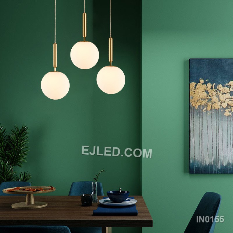 This single pendant light features a clear round glass shade encased by a polished brass frame. It suspends from a fabric-covered cord, casting a focused downlight and adding visual interest to dining areas, bedside tables, or compact reception spaces. - view 5