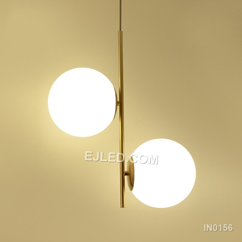 This double pendant light features two individual lamps, each with a clear round glass shade framed by polished brass. Suspended from a single rectangular canopy, it provides direct and ambient light, making it suitable for dining tables, kitchen islands, or long reception counters.