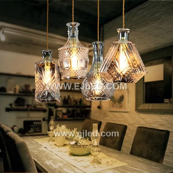 This single pendant light features an enclosed, translucent smoke-grey glass globe shade, directing a diffuse light through its spherical form. A visible lamp sits within, capped by a black and golden fixture, ideal for focused illumination in various settings. - view 2