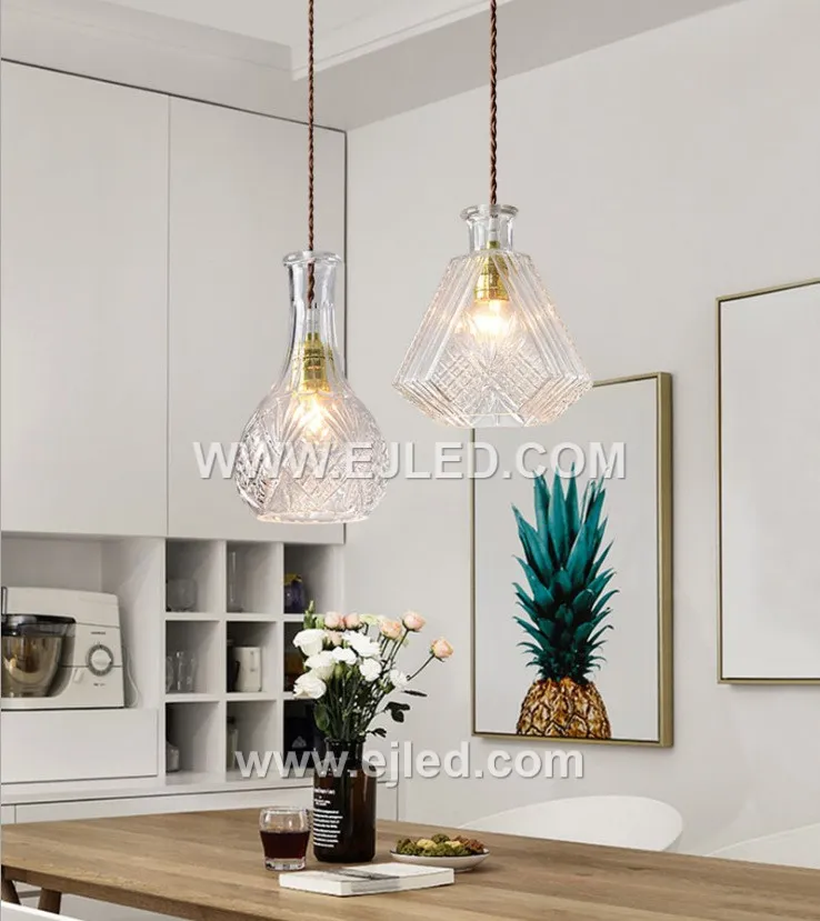 This single pendant light features an enclosed, translucent smoke-grey glass globe shade, directing a diffuse light through its spherical form. A visible lamp sits within, capped by a black and golden fixture, ideal for focused illumination in various settings. - view 3