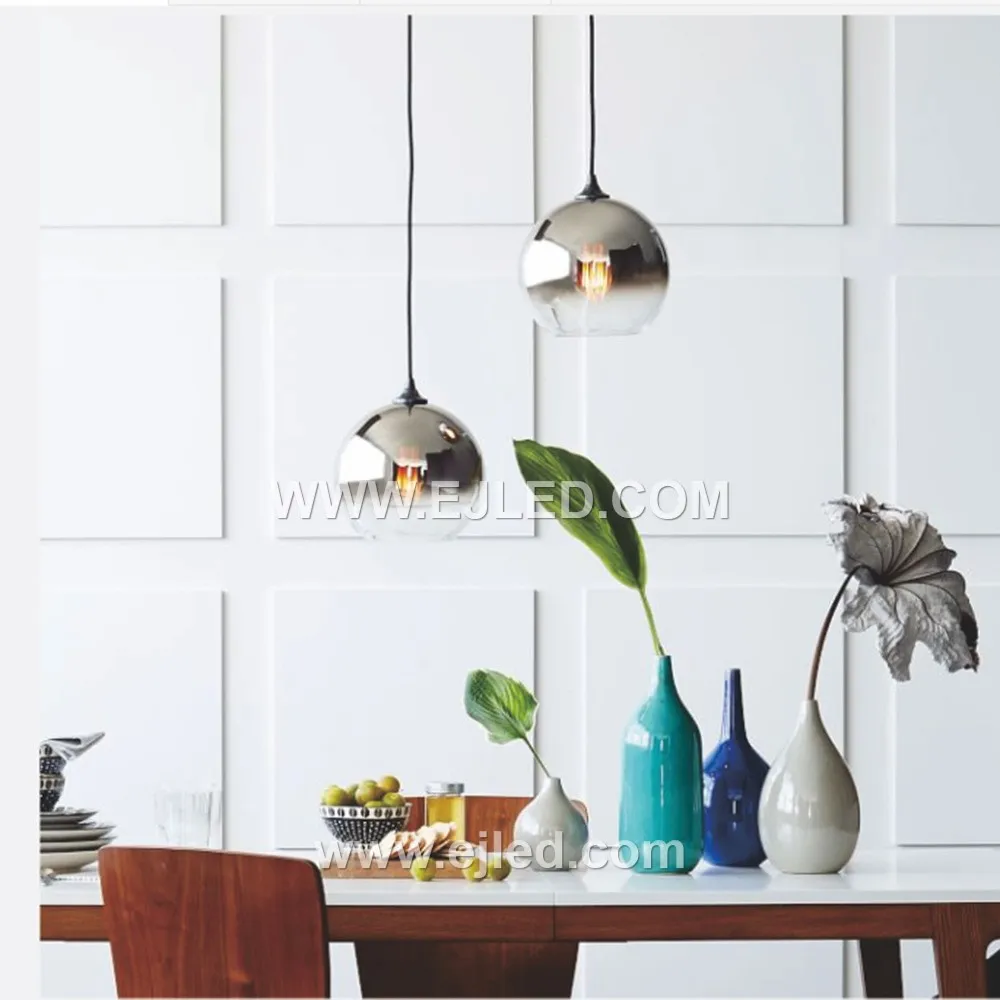 Model GL0002 is a single-lamp pendant featuring a large, clear spherical glass shade of 20cm diameter, suitable for creating a bright, open feel. Its golden-brushed brass finish suspension provides a refined contrast to the transparent globe.
