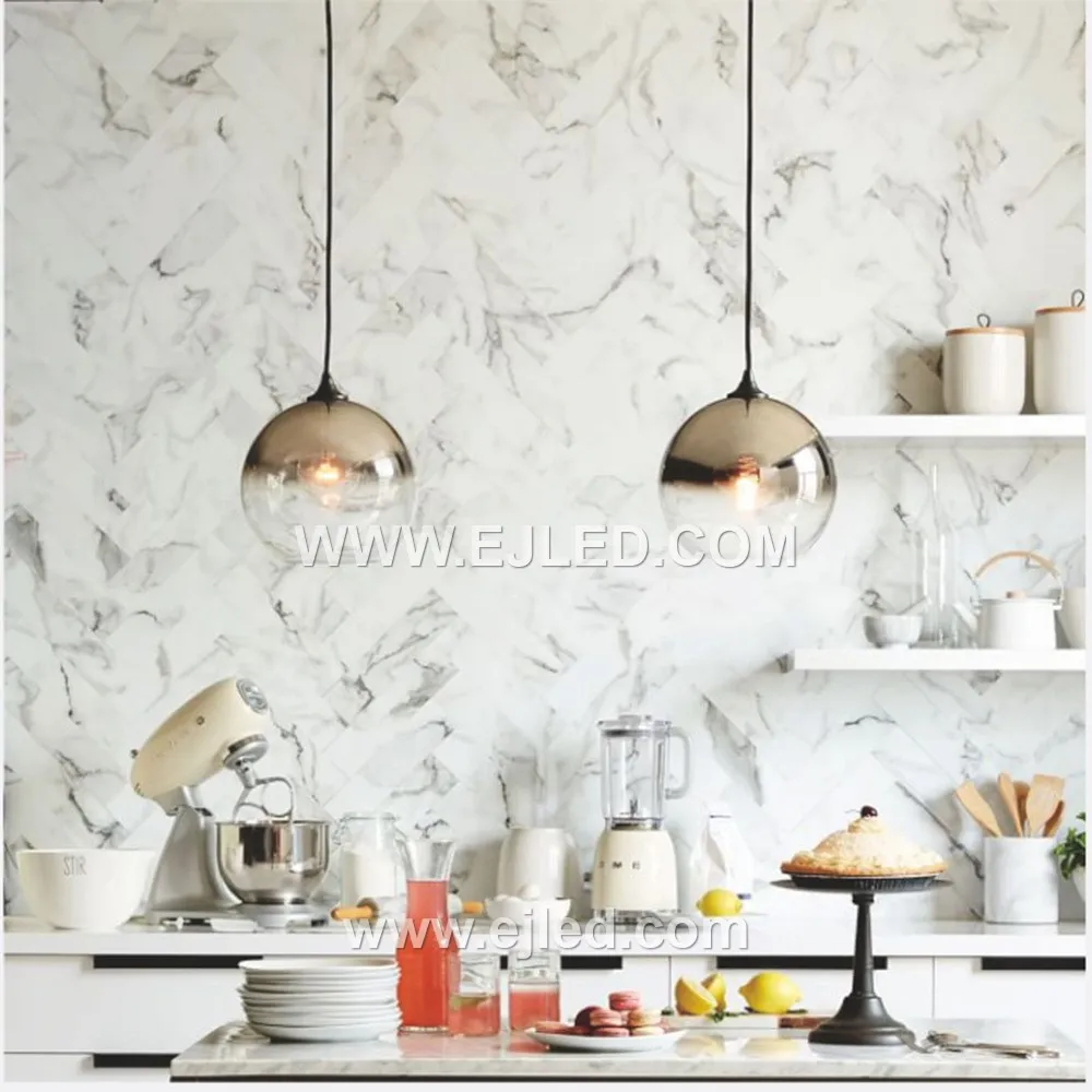 Model GL0002 is a single-lamp pendant featuring a large, clear spherical glass shade of 20cm diameter, suitable for creating a bright, open feel. Its golden-brushed brass finish suspension provides a refined contrast to the transparent globe. - view 3