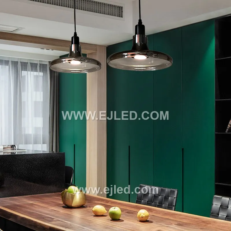 Clear glass forms the small, distinctive D9*11 cylindrical shade of the GL0007 pendant, allowing full visibility of a single decorative lamp. A golden-finished top and braided clear cable complete its minimalist design. - view 3