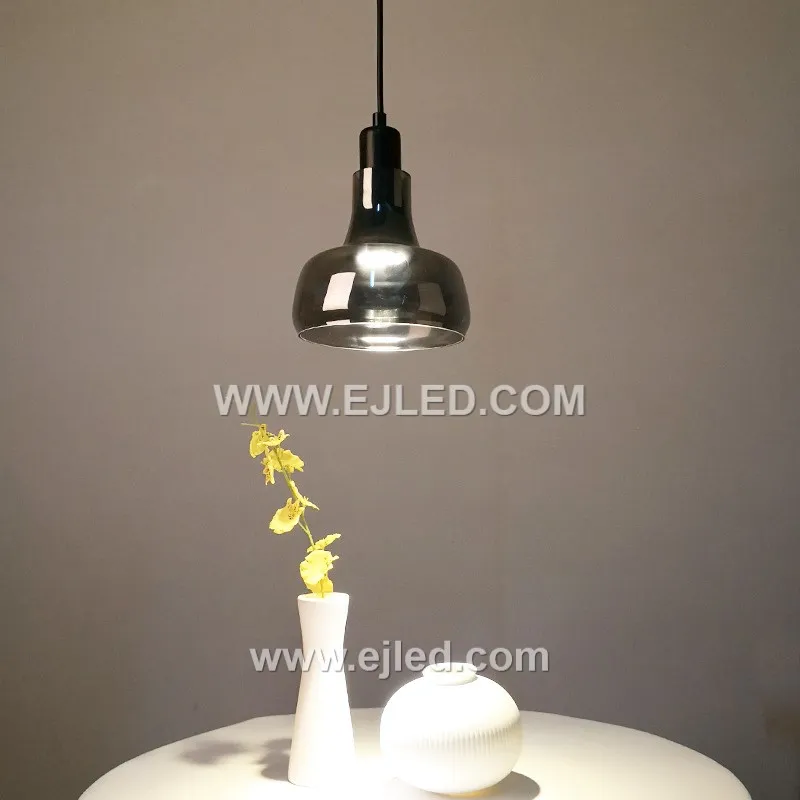 Clear glass forms the small, distinctive D9*11 cylindrical shade of the GL0007 pendant, allowing full visibility of a single decorative lamp. A golden-finished top and braided clear cable complete its minimalist design. - view 4