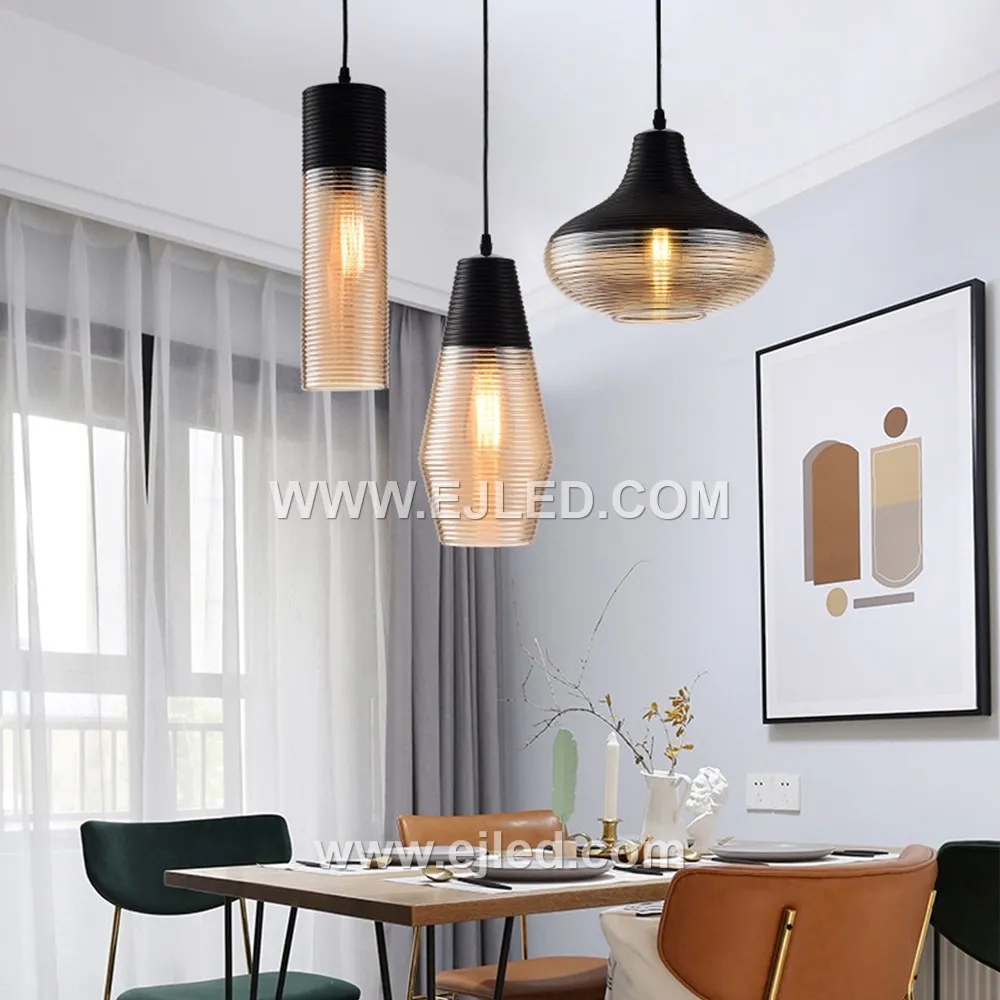 A single glass pendant light, model GL0009, illuminates spaces with a downwards glow, ideal for task lighting over kitchen islands or as accent lighting in hotel lobbies. Its cylindrical shade is crafted from black glass with a subtle golden inner hue. - view 2