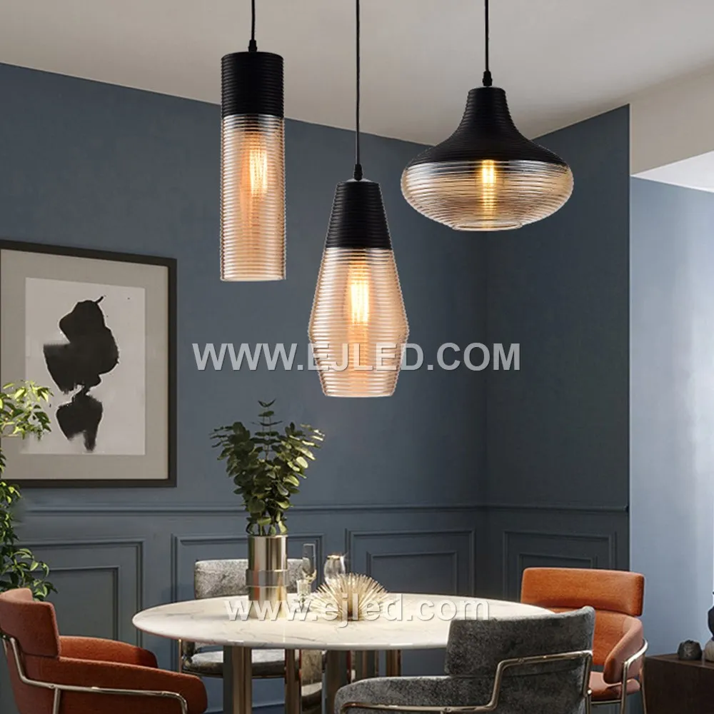 A single glass pendant light, model GL0009, illuminates spaces with a downwards glow, ideal for task lighting over kitchen islands or as accent lighting in hotel lobbies. Its cylindrical shade is crafted from black glass with a subtle golden inner hue. - view 3