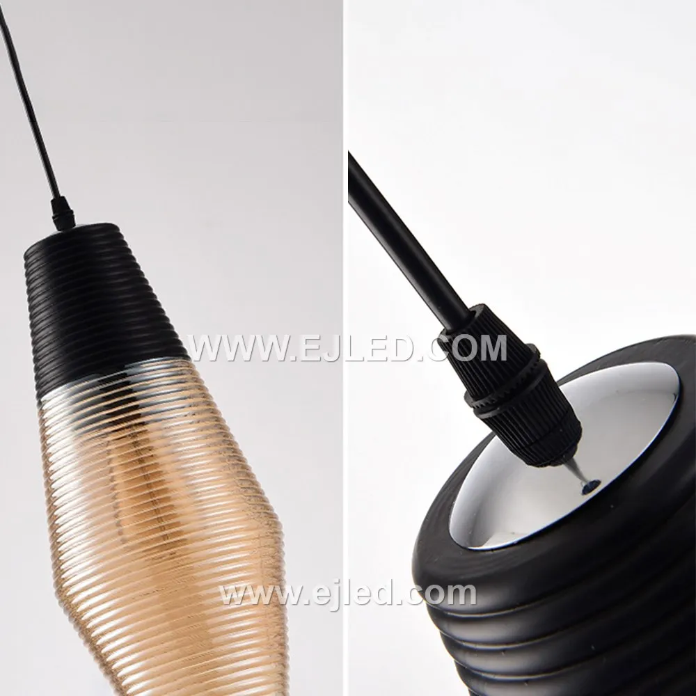 A single glass pendant light, model GL0009, illuminates spaces with a downwards glow, ideal for task lighting over kitchen islands or as accent lighting in hotel lobbies. Its cylindrical shade is crafted from black glass with a subtle golden inner hue. - view 6