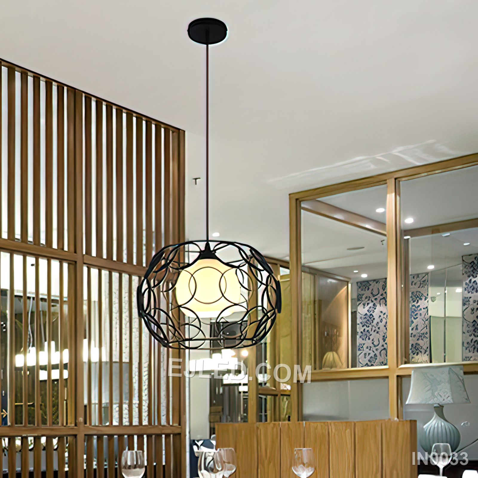 Suited for diverse settings, this drum-shaped pendant light features a black powder-coated iron cage enveloping an inner frosted glass sphere. This combination provides both ambient glow and a defined industrial aesthetic. - view 2