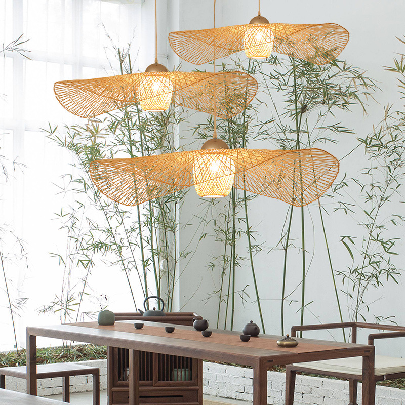Model RT0033 features a wide, conical bamboo pendant shade, hand-woven with a natural finish. Its expansive open bottom directs a broad light spread, ideal for illuminating larger surfaces like dining tables or reception desks. - view 3