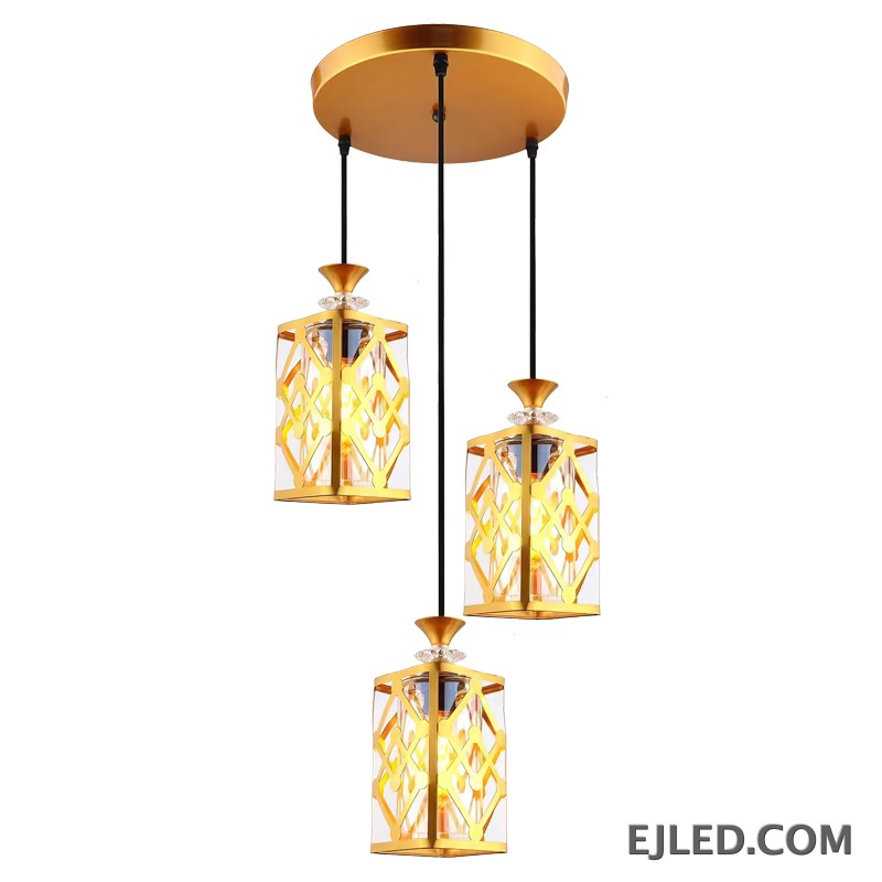 This fixture features three brass and clear glass pendant lights, each with an enclosed design, hanging from a single gold-finished canopy, casting a warm glow. - view 6
