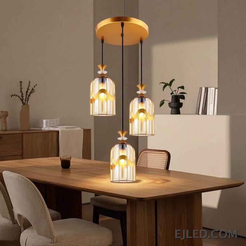 This pendant light features a clear glass cylindrical shade, capped with a sleek gold-finished brass element. It provides focused downward illumination from a single lamp, ideal for accent lighting or clustered arrangements. - view 3