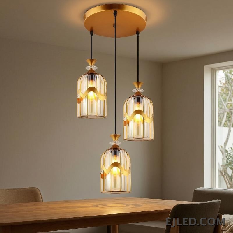 This pendant light features a clear glass cylindrical shade, capped with a sleek gold-finished brass element. It provides focused downward illumination from a single lamp, ideal for accent lighting or clustered arrangements. - view 4