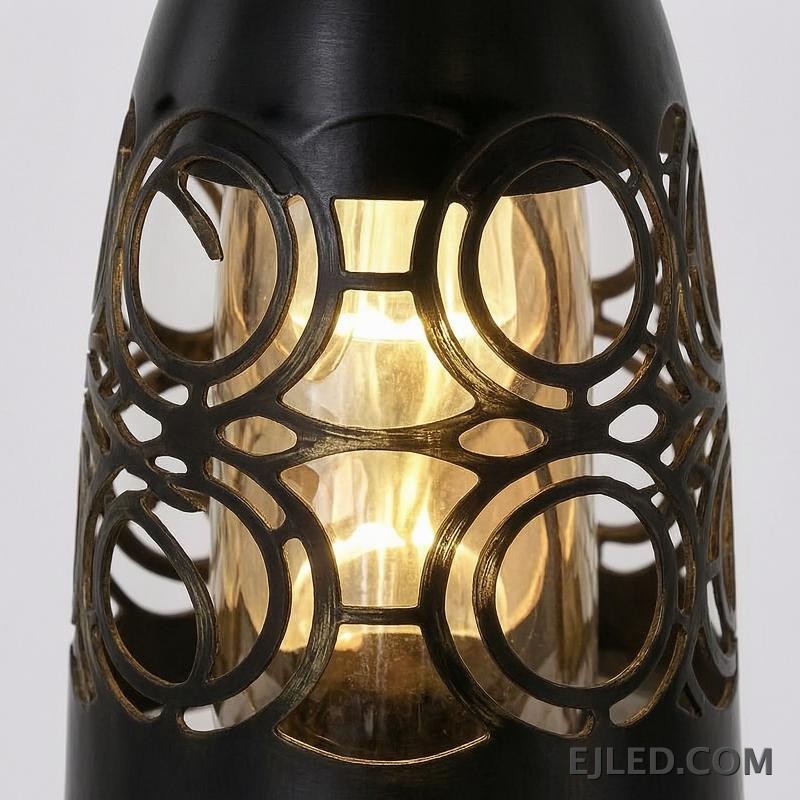 This three-light pendant cluster features black iron bell-shaped shades. Each shade has a solid top and a lower section with a distinct cut-out circular pattern, allowing light to emanate through the sides and open bottom. - view 5