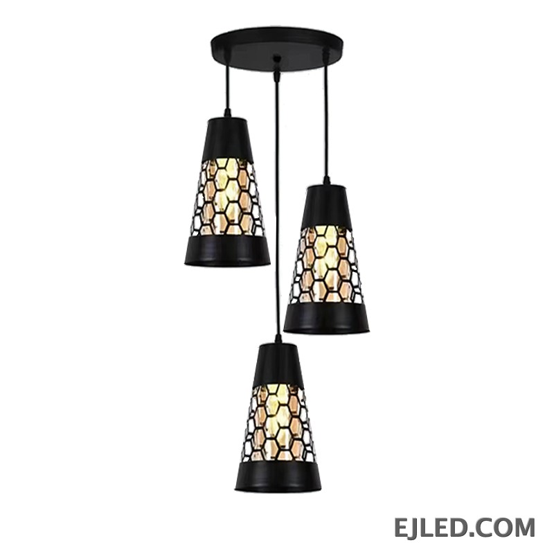 This triple pendant light features black iron conical shades. Each shade has a honeycomb cut-out pattern revealing a golden interior, suspended from a round black ceiling plate.