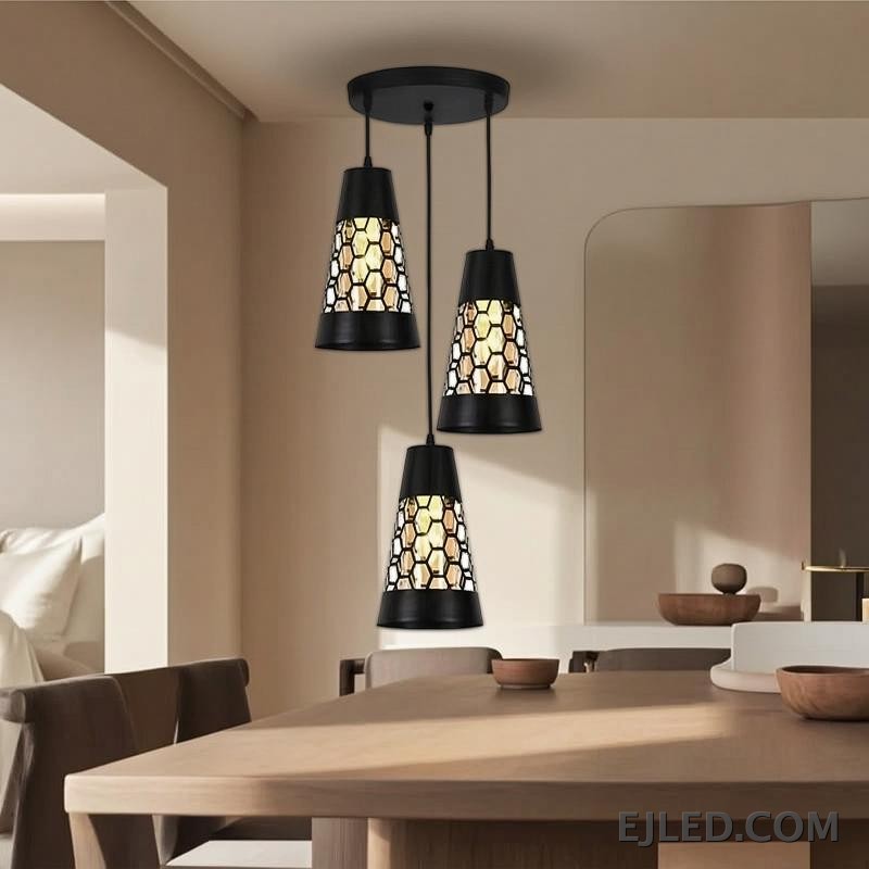 This triple pendant light features black iron conical shades. Each shade has a honeycomb cut-out pattern revealing a golden interior, suspended from a round black ceiling plate. - view 3