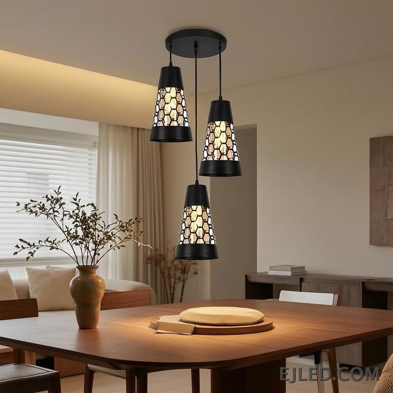 This triple pendant light features black iron conical shades. Each shade has a honeycomb cut-out pattern revealing a golden interior, suspended from a round black ceiling plate. - view 5