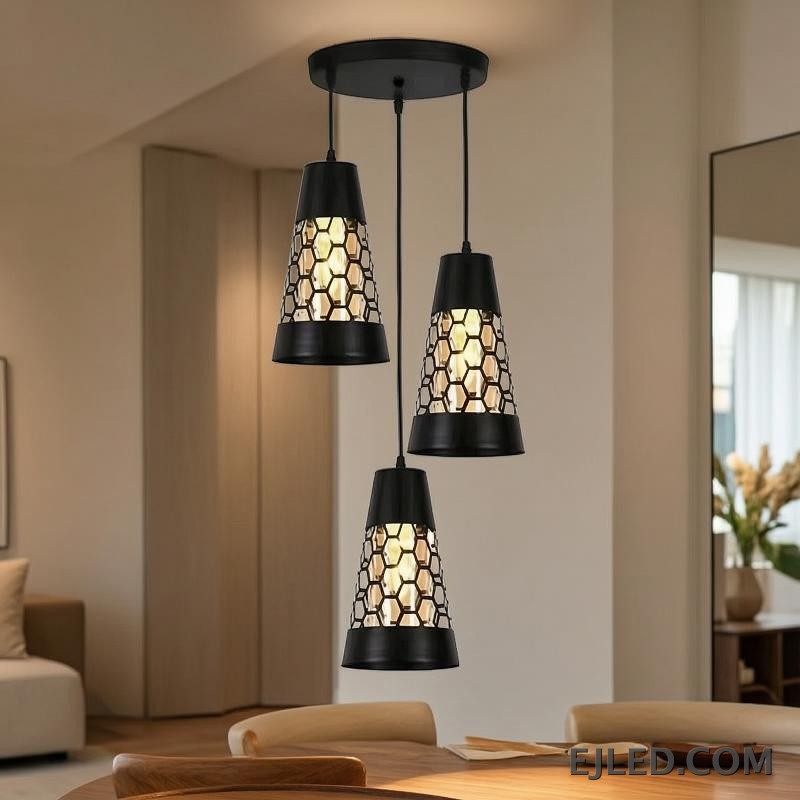 This triple pendant light features black iron conical shades. Each shade has a honeycomb cut-out pattern revealing a golden interior, suspended from a round black ceiling plate. - view 6