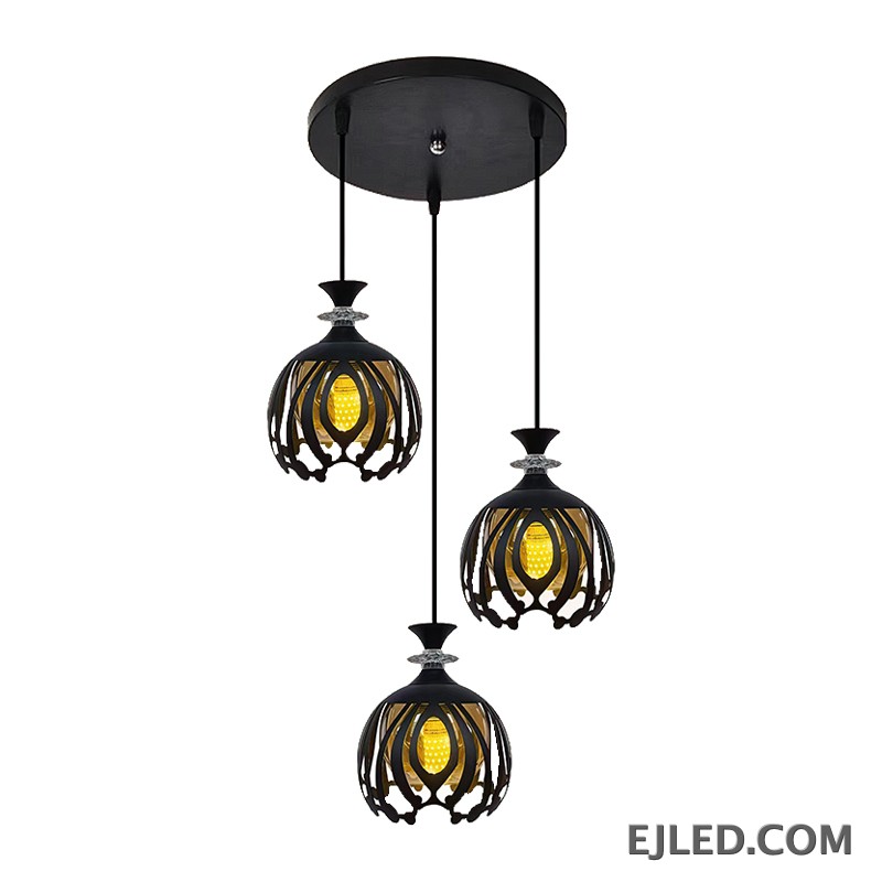 This BS0012 pendant fixture features three black iron lamps, each with a round openwork cage shade that reveals a golden interior light, topped with a clear faceted accent.