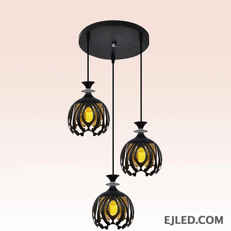 Esta lámpara colgante BS0012 cuenta con tres luces de hierro negro, cada una con una pantalla de jaula calada redonda que revela una luz interior dorada, rematada con un acento facetado transparente. - view 2