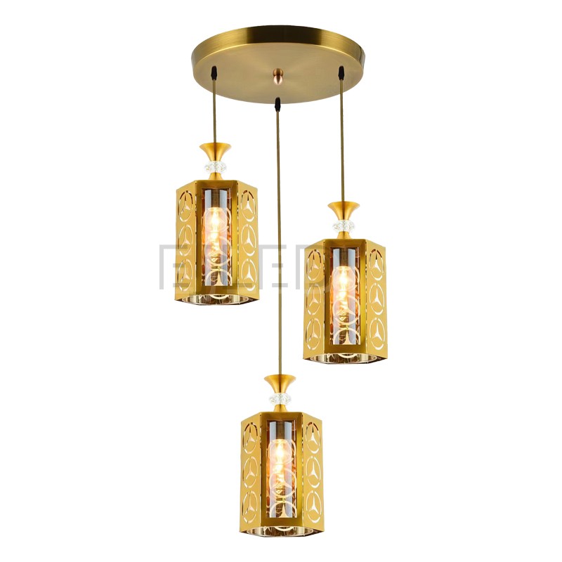 This gold brass pendant light features three cylindrical shades suspended from a matching round ceiling plate, each housing a single bulb behind patterned metal cutouts.