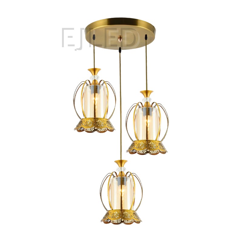 This three-light pendant features matching bell-shaped glass shades housed in ornate brass frames hanging from a circular gold ceiling canopy.