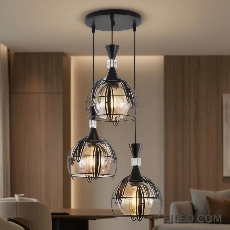 Una pantalla de vidrio esférica transparente define esta lámpara colgante, rematada por un elemento de hierro con acabado oscuro. Aloja una sola lámpara, ofreciendo iluminación ambiental amplia, ideal para interiores contemporáneos y de transición. - view 3