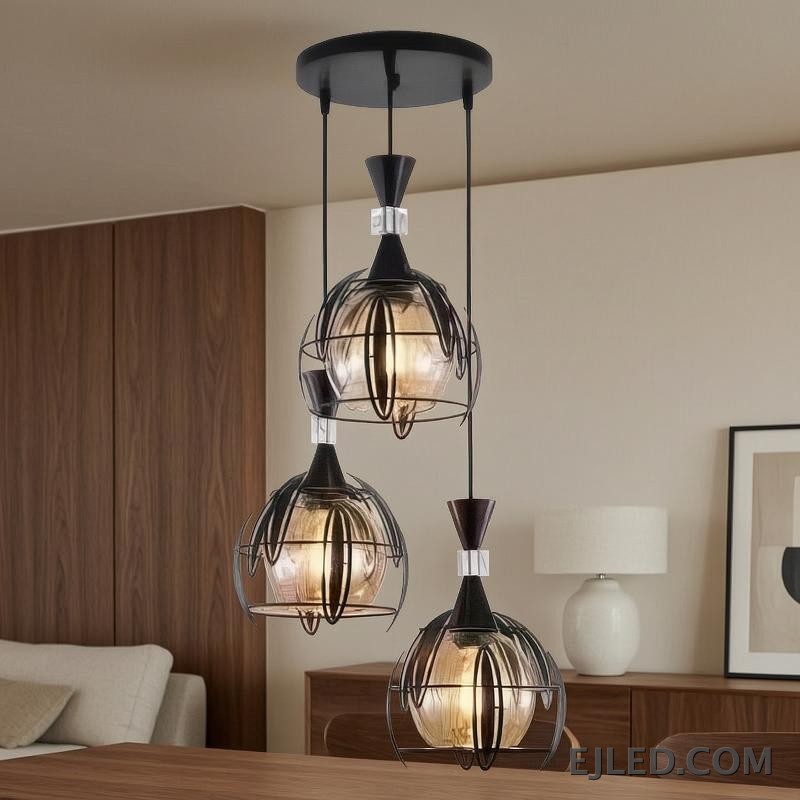 Una pantalla de vidrio esférica transparente define esta lámpara colgante, rematada por un elemento de hierro con acabado oscuro. Aloja una sola lámpara, ofreciendo iluminación ambiental amplia, ideal para interiores contemporáneos y de transición. - view 4