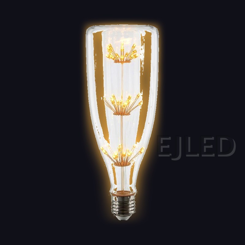 This clear glass starry LED bulb features a tall bottle shape and three vertical tiers of delicate firework style filaments connected to a standard screw base. - view 2
