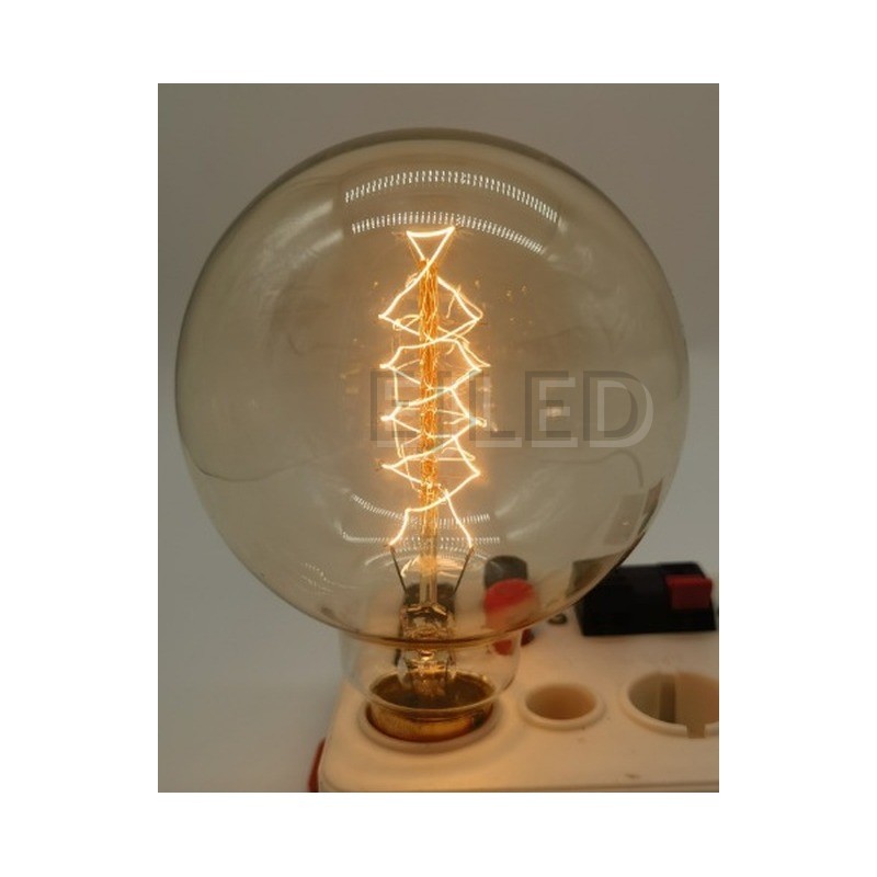 This amber glass G95 incandescent bulb features a spiral tungsten filament inside a large round globe. It operates on standard household voltage with a threaded brass base. - view 6