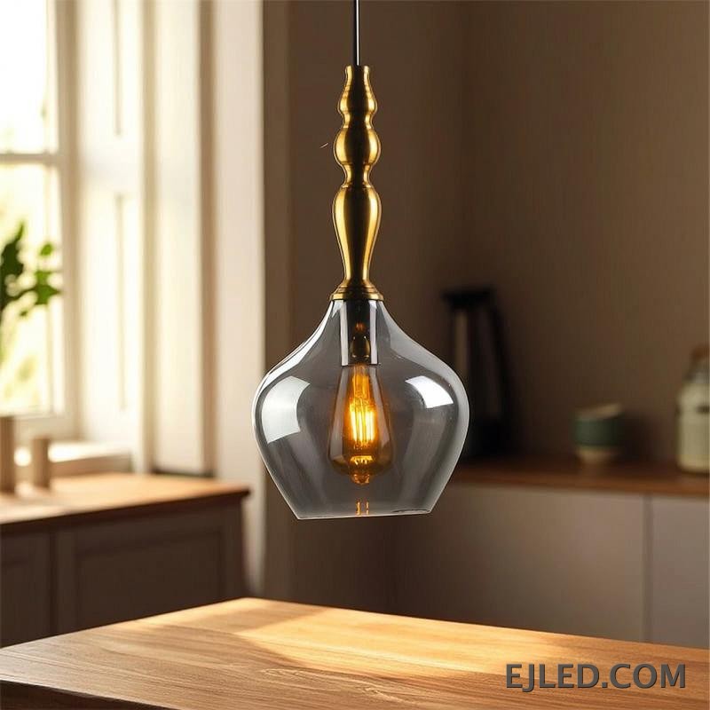 Una lámpara colgante de cristal, la GL0006 presenta una pantalla esférica transparente suspendida de un accesorio de latón. Su diseño abierto permite una amplia distribución de la luz, haciéndola adecuada para iluminación general o para resaltar áreas específicas con una bombilla expuesta. - view 5