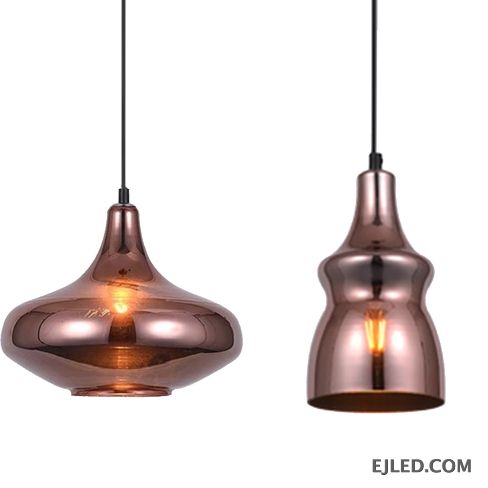 This collection features reflective copper-toned glass pendant lights in three distinct bell shapes. Each fixture houses a single bulb, providing warm, downward illumination. - view 2