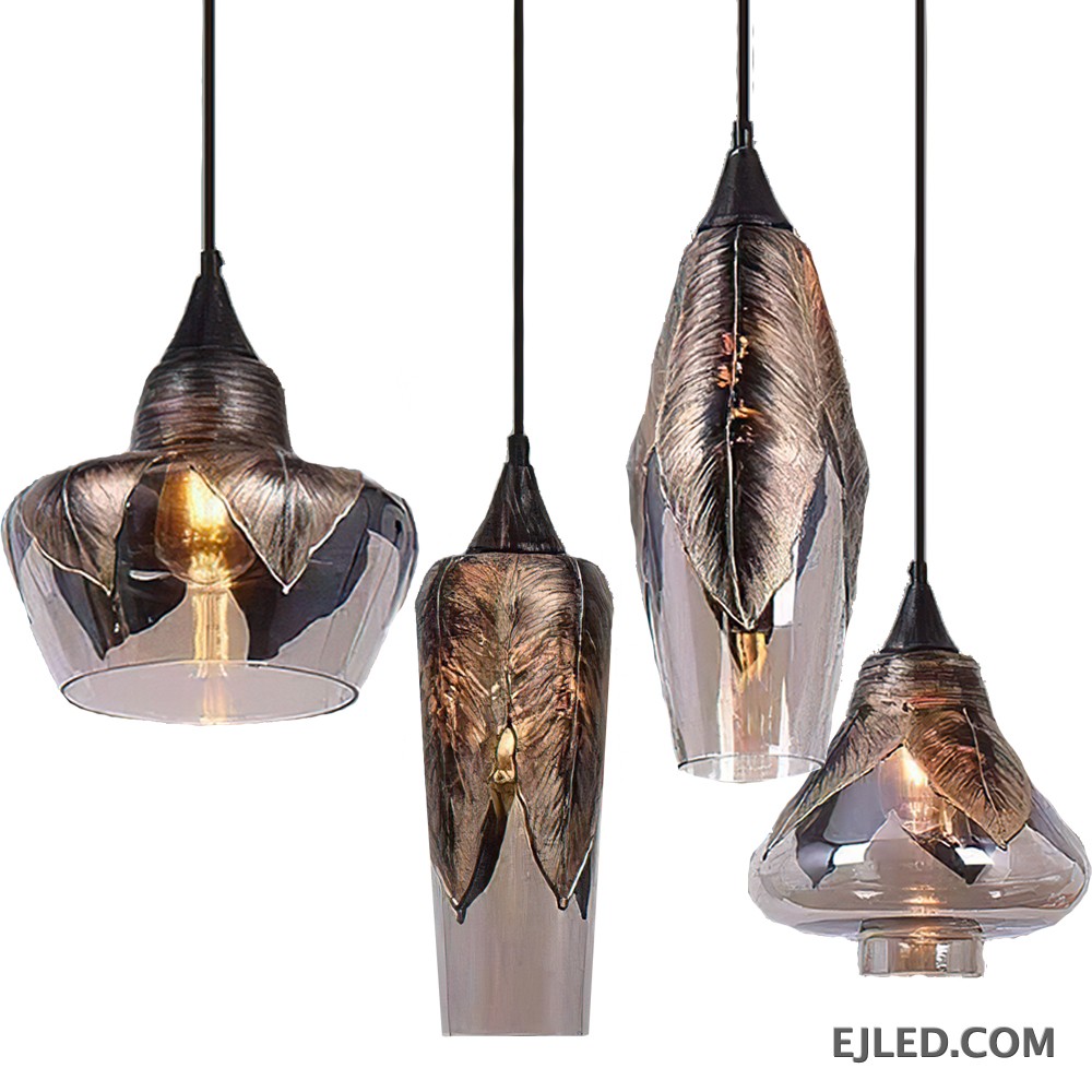 This collection features four distinct glass pendant light styles, each characterized by a smoked finish and striking metallic feather-like embellishments. These fixtures offer varied shapes, from bell-shaped to elongated, providing diverse aesthetic options.