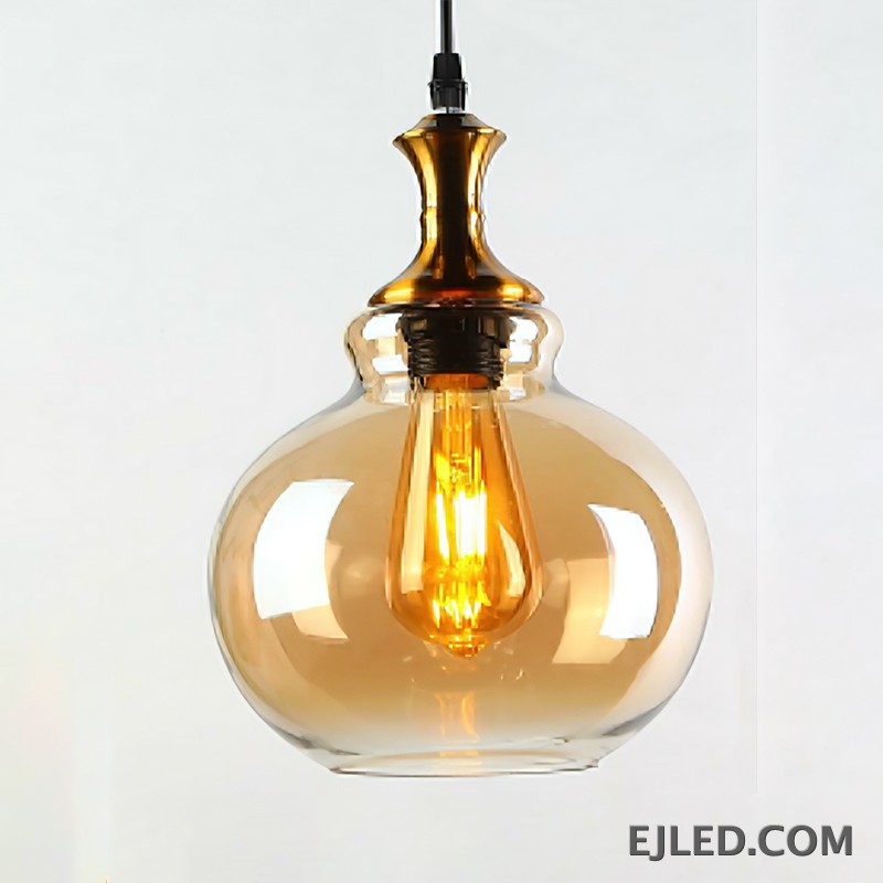 This glass pendant light features a spherical, amber-tinted shade that encloses a single exposed filament bulb. It hangs from a black suspension cord, complemented by a polished gold-finished metal cap. - view 2