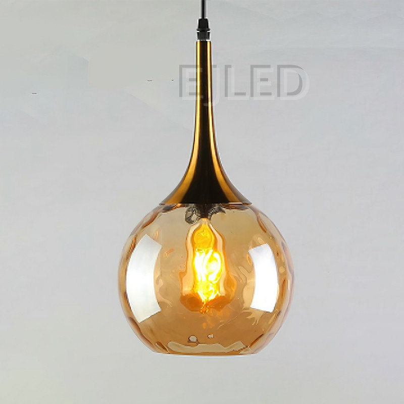 This pendant light features an amber glass globe shade paired with a polished copper top and a single exposed bulb inside. - view 2