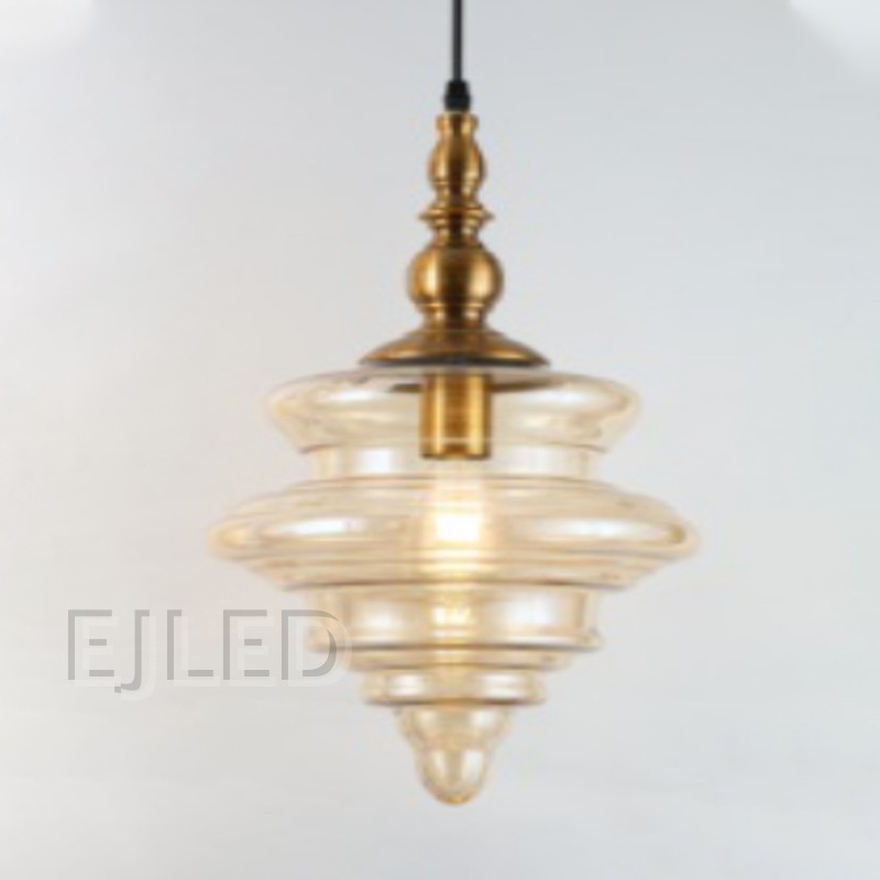 This distinctive amber glass pendant light features a sculpted shade suspended from an ornate brass finial. Its single lamp is enclosed within the translucent, bell-shaped glass, offering a warm glow for various interior settings. - view 2