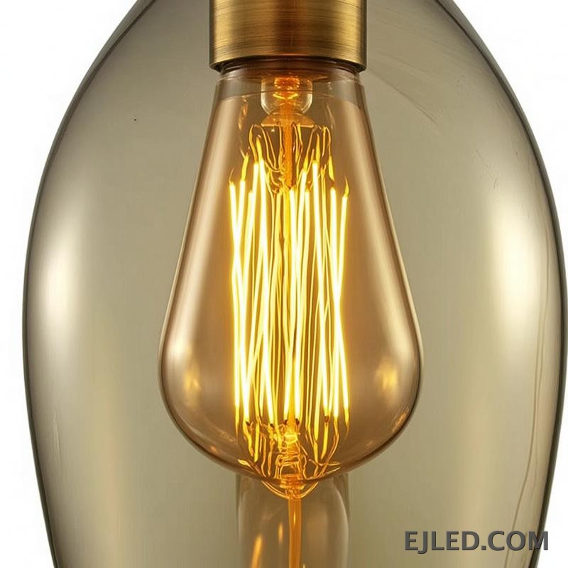 Esta lámpara colgante de cristal presenta una pantalla única asimétrica en forma de hoja con un tono ámbar cálido, que aloja una sola lámpara visible con portalámparas en tono latón. Cuelga de un cable negro sencillo y ofrece una base abierta para la difusión de la luz. - view 6